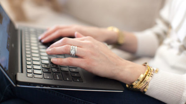 Jayne working on a laptop wearing her Lillian & Co. jewelry